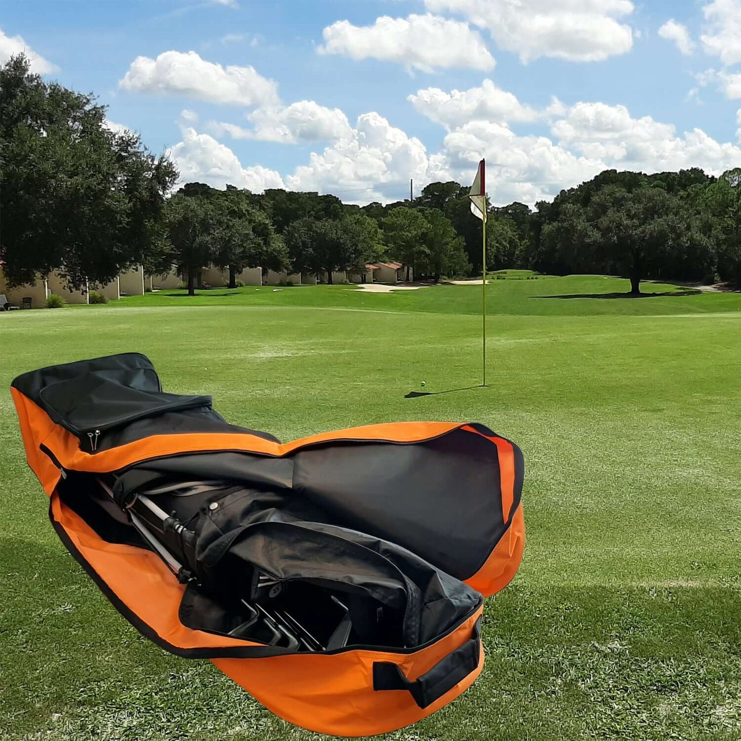 Orange and black Fortitude Sports golf travel bag on a golf course with trees and sky in the background